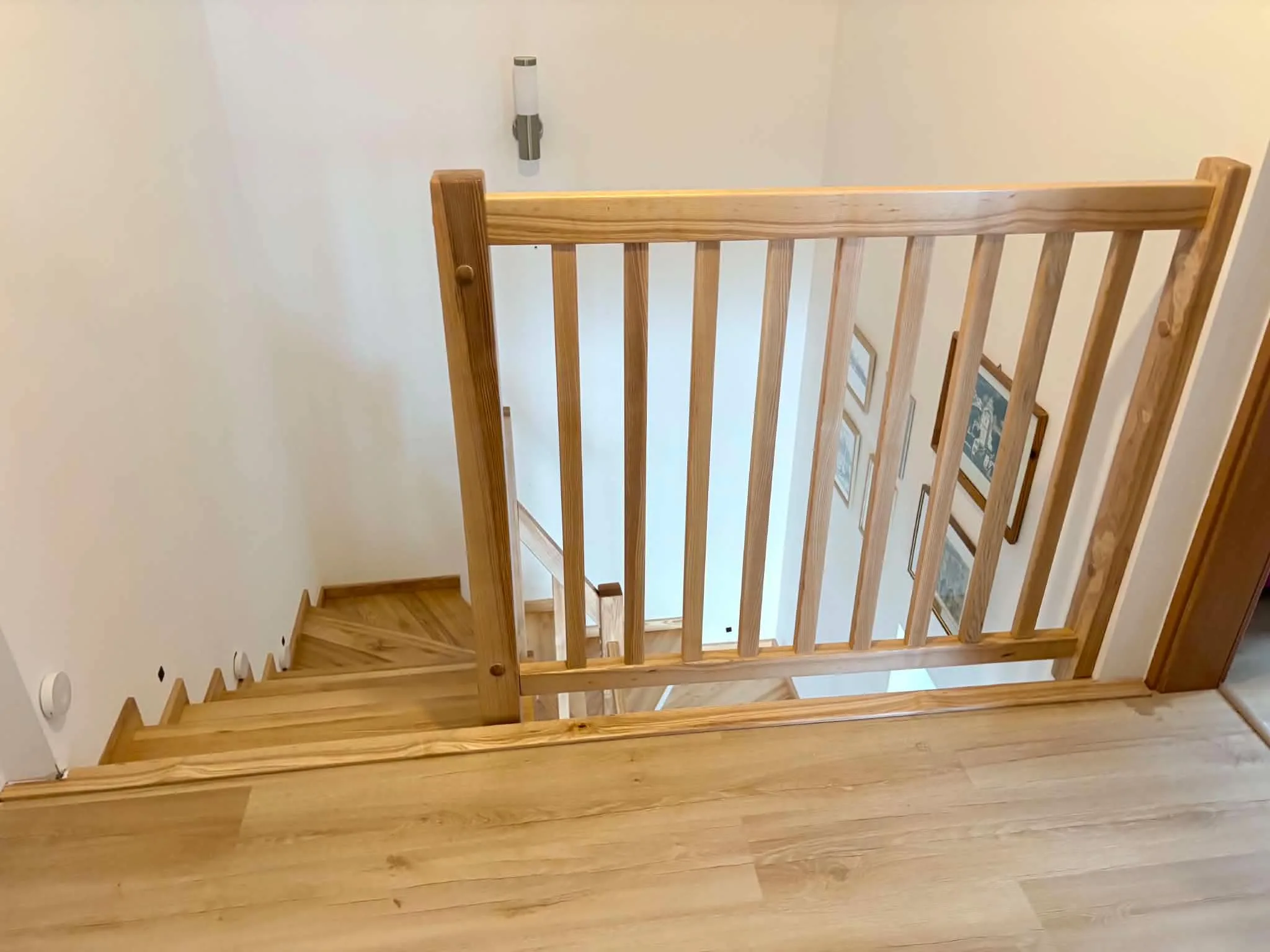 Schody z białą balustradą i drewnianym pochwytem