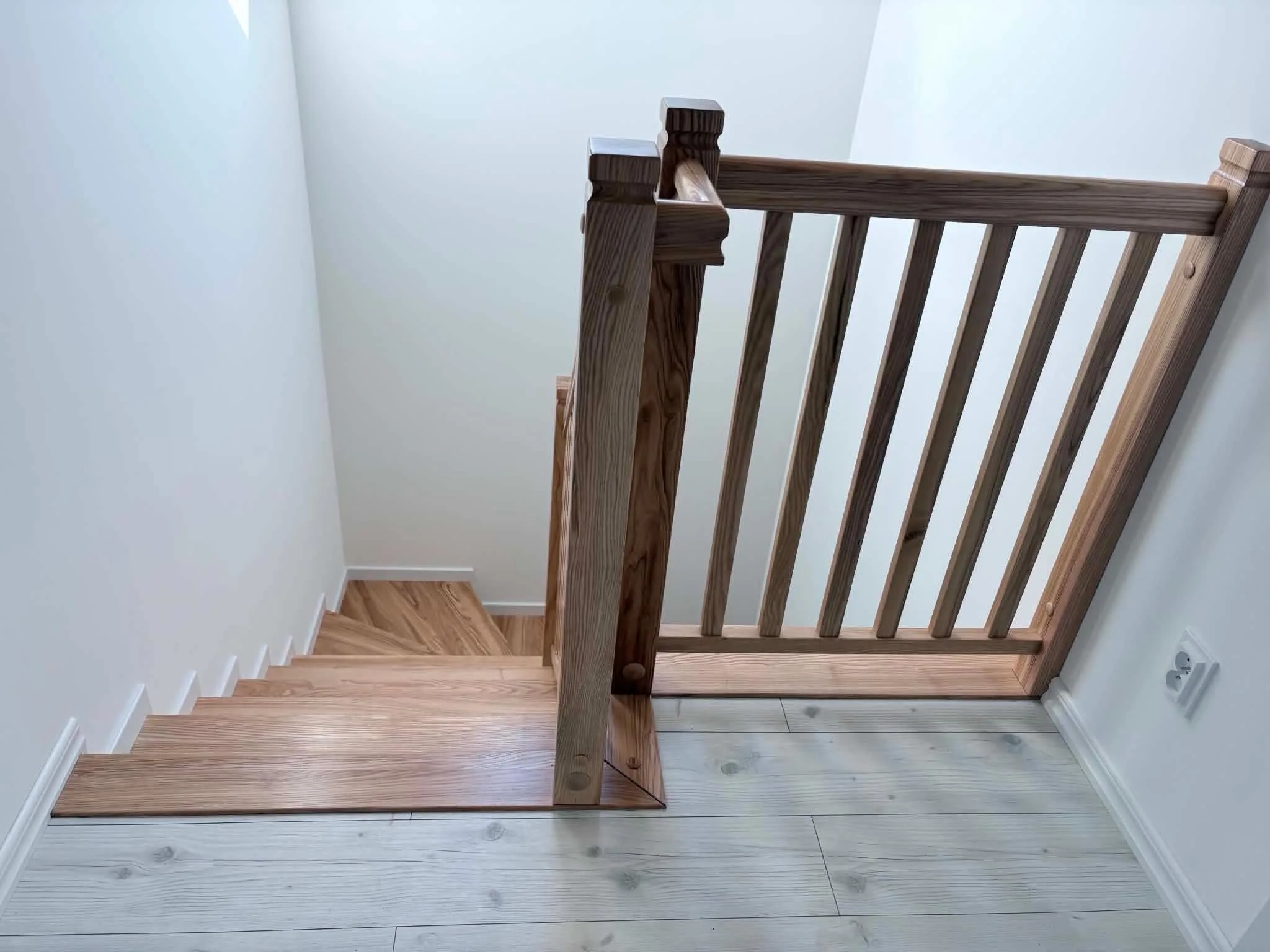 Schody z ciemną drewnianą balustradą